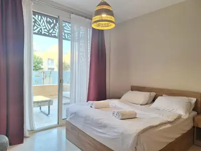 a bedroom with a bed and a large window at Mangroovy- 1br Imposing, Relaxing & Sea View in Hurghada