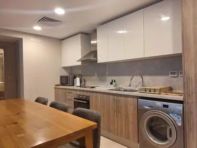 a kitchen with a table and a washing machine at Mangroovy- 1br Imposing, Relaxing & Sea View in Hurghada