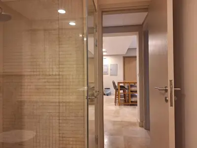 a glass shower door in a room with a table at Mangroovy- 1br Imposing, Relaxing & Sea View in Hurghada