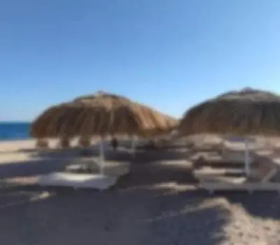 a group of straw umbrellas on a beach at Avenue Alhambra in Hurghada