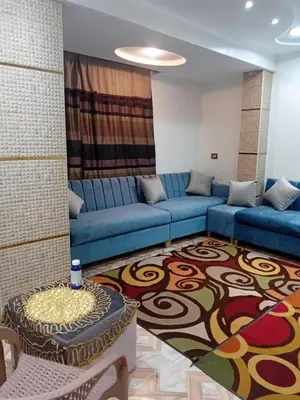 a living room with a blue couch and a rug at Luxor in Luxor