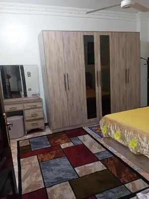 a bedroom with a bed and wooden cabinets at Luxor in Luxor