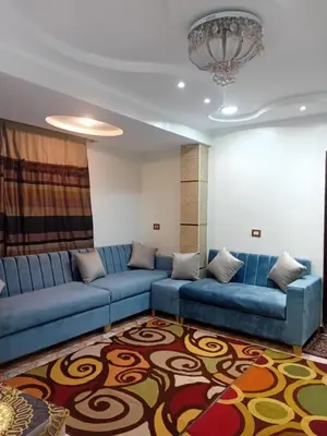 a living room with blue couches and a rug at Luxor in Luxor
