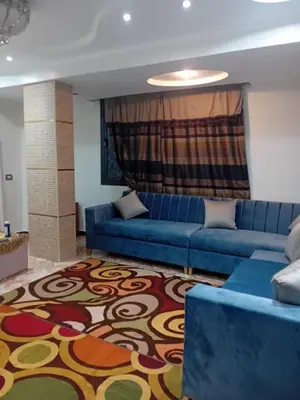 a living room with a blue couch and a rug at Luxor in Luxor