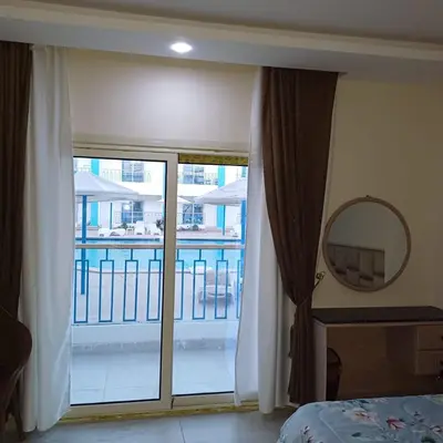 a bedroom with a large window with a view of a balcony at Mirage Bay Resort & Aqua Park in Hurghada