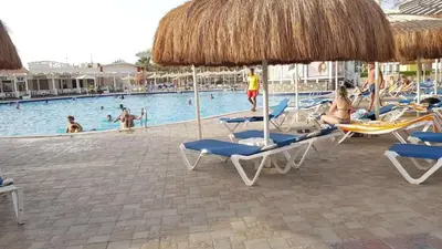 a group of chairs and umbrellas at a swimming pool at Mirage Bay Resort & Aqua Park in Hurghada
