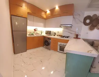 a small kitchen with a refrigerator and a dishwasher at Beachfront Boho Style apartment in Fanadir Bay in Hurghada