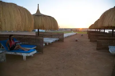 a woman sitting on a beach chair on the beach at Beachfront Boho Style apartment in Fanadir Bay in Hurghada