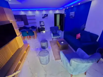 a living room with a blue couch and chairs at Fanadir Bay Compound in Hurghada