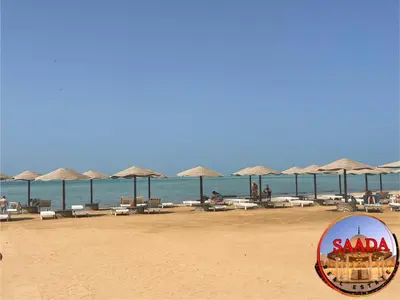 a beach with chairs and umbrellas and the ocean at Fanadir Bay Compound in Hurghada