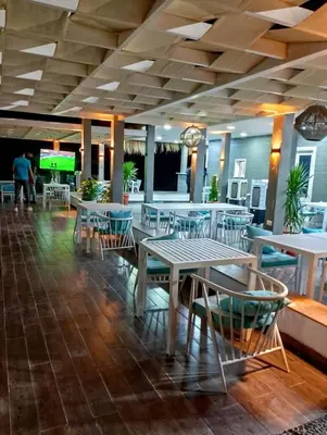 a restaurant with tables and chairs and a television at Fanadir Bay Compound in Hurghada