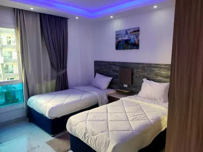 a hotel room with two beds and a window at Fanadir Bay Compound in Hurghada