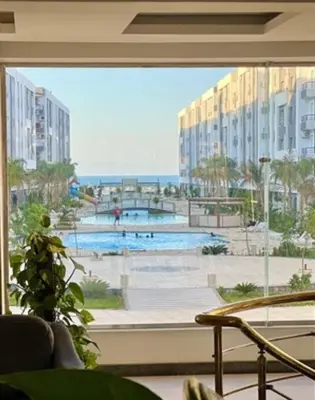 a view of a pool from a large window at Fanadir Bay Compound in Hurghada