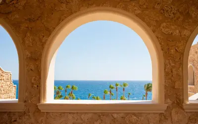 an arched window with a view of the ocean at Resort-Style Luxury Chalet with Pool and Sea View in Sahl Hasheesh in Hurghada