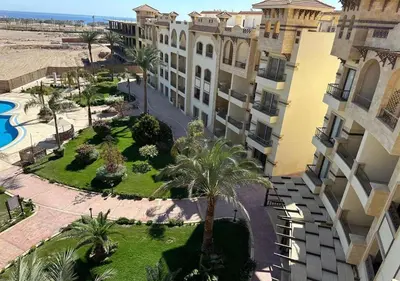 an aerial view of a building with palm trees and a courtyard at Resort-Style Luxury Chalet with Pool and Sea View in Sahl Hasheesh in Hurghada