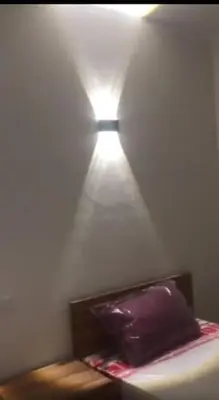 a room with a bed with a light on the wall at Nový byt ve vyhledávané lokalitě in Hurghada
