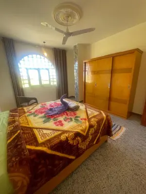 a bedroom with a bed and a dresser at Flat in Kom in Luxor