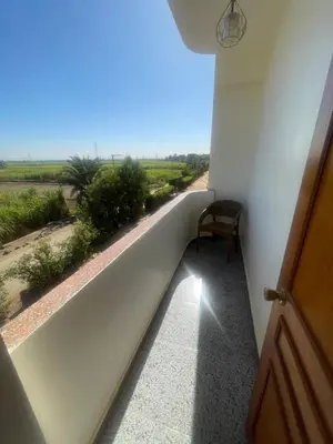 a room with a balcony with a table and a chair at Flat in Kom in Luxor