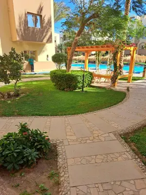 a walkway in a park next to a pool at Beach front 2BR at elkarma hotel & aqua park in Hurghada