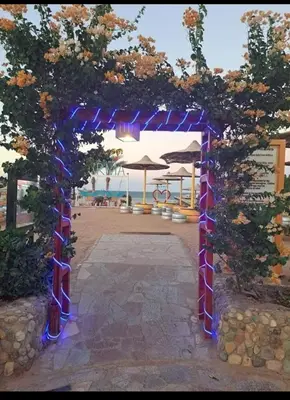 an archway with blue lights in front of a beach at Beach front 2BR at elkarma hotel & aqua park in Hurghada