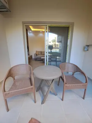 a table and two chairs and a table and chairs at Beach front 2BR at elkarma hotel & aqua park in Hurghada