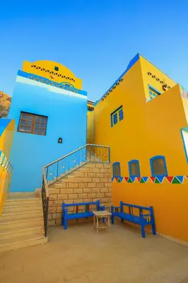 a yellow and blue building with two blue benches at Nubiano Cataract in Shellal