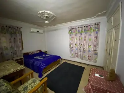 a small room with a bed and two curtains at Hotelمفروش in Aswan