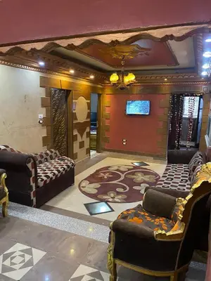 a living room with couches and a flat screen tv at Hotelمفروش in Aswan