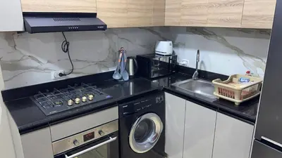 a small kitchen with a stove and a sink at Serenity Cozy Studio Direct to the Pool In Hurghada in Hurghada
