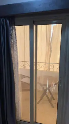 a glass window with a table in a room at Serenity Cozy Studio Direct to the Pool In Hurghada in Hurghada