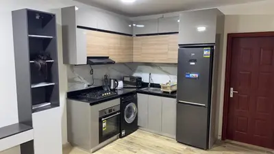 a kitchen with a stove and a washer and dryer at Serenity Cozy Studio Direct to the Pool In Hurghada in Hurghada