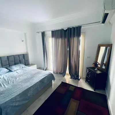 a bedroom with a bed and a large window at 1 plus 1 in city centre Hurghada in Hurghada