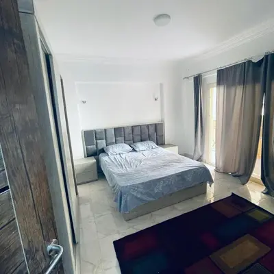 a bedroom with a bed and a large window at 1 plus 1 in city centre Hurghada in Hurghada