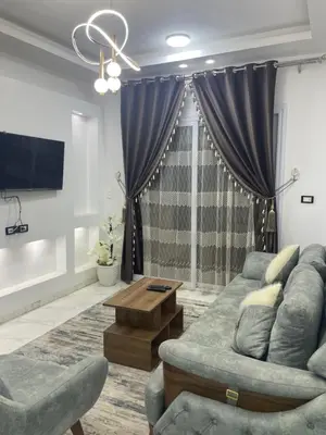 a living room with a couch and a tv at Fantasy home in Al Aqālitah