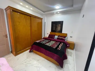 a bedroom with a bed and a wooden door at Fantasy home in Al Aqālitah