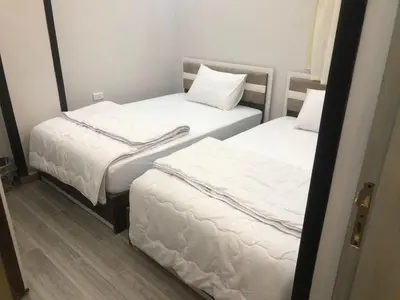 two beds in a small room with white sheets at El Hadaba behind Raya in Hurghada