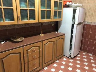 a kitchen with wooden cabinets and a refrigerator at Apartment sea view in Hurghada