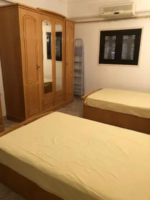 a bedroom with two beds and a cabinet at Apartment sea view in Hurghada