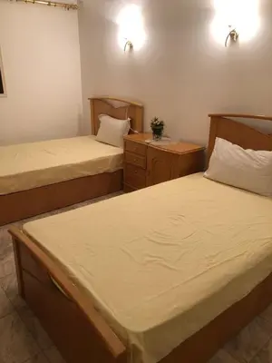 a bedroom with two beds and a nightstand and two beds sidx sidx sidx sidx at Apartment sea view in Hurghada