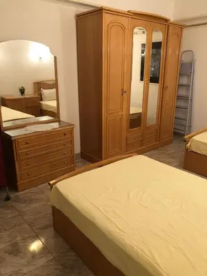 a bedroom with two beds and a dresser and a mirror at Apartment sea view in Hurghada