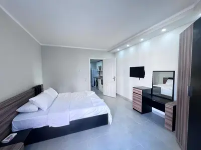 a white bedroom with a bed and a desk at Scandic Hotel Hurghada in Hurghada