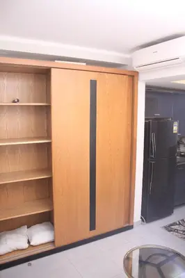 a kitchen with wooden cabinets and a black refrigerator at Scandic Hotel Hurghada in Hurghada