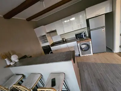 a kitchen with a counter with chairs and a refrigerator at Luxury one bedroom in Hurghada