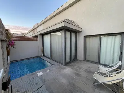 a house with a swimming pool and two chairs at Luxury one bedroom in Hurghada