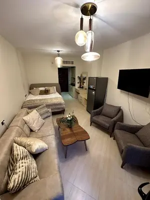 a living room with a couch and a bed and a television at studio in a 5 star hotel in Hurghada
