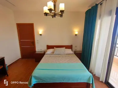 a bedroom with a bed and a chandelier at Luxury 2 bedroom in fandir el gouna in Hurghada