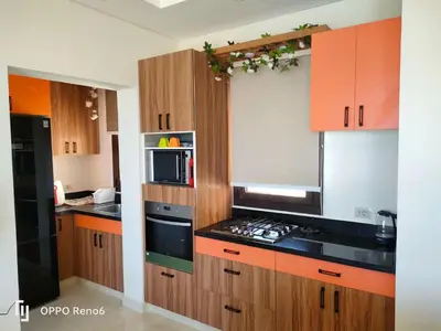a kitchen with wooden cabinets and a stove top oven at Luxury 2 bedroom in fandir el gouna in Hurghada
