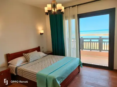 a bedroom with a bed and a large window with the ocean at Luxury 2 bedroom in fandir el gouna in Hurghada