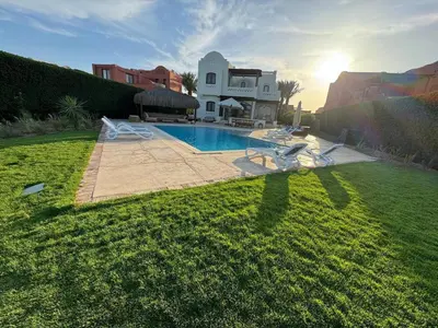 a house with a swimming pool in a yard at Luxury villa west golf in Hurghada