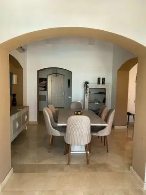 a dining room with a table and some chairs at Luxury villa west golf in Hurghada